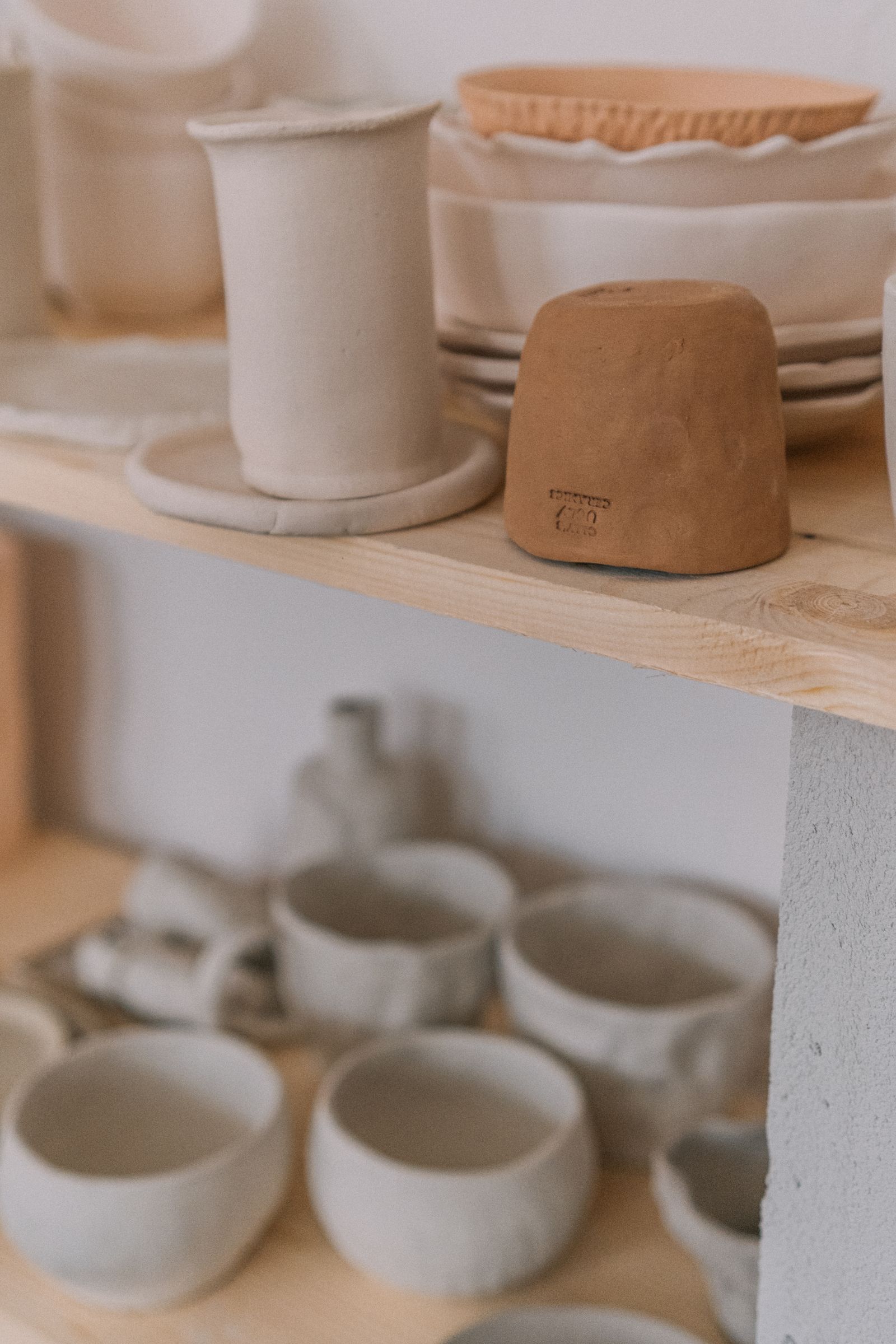 Unfinished ceramic cups on studio shelves
