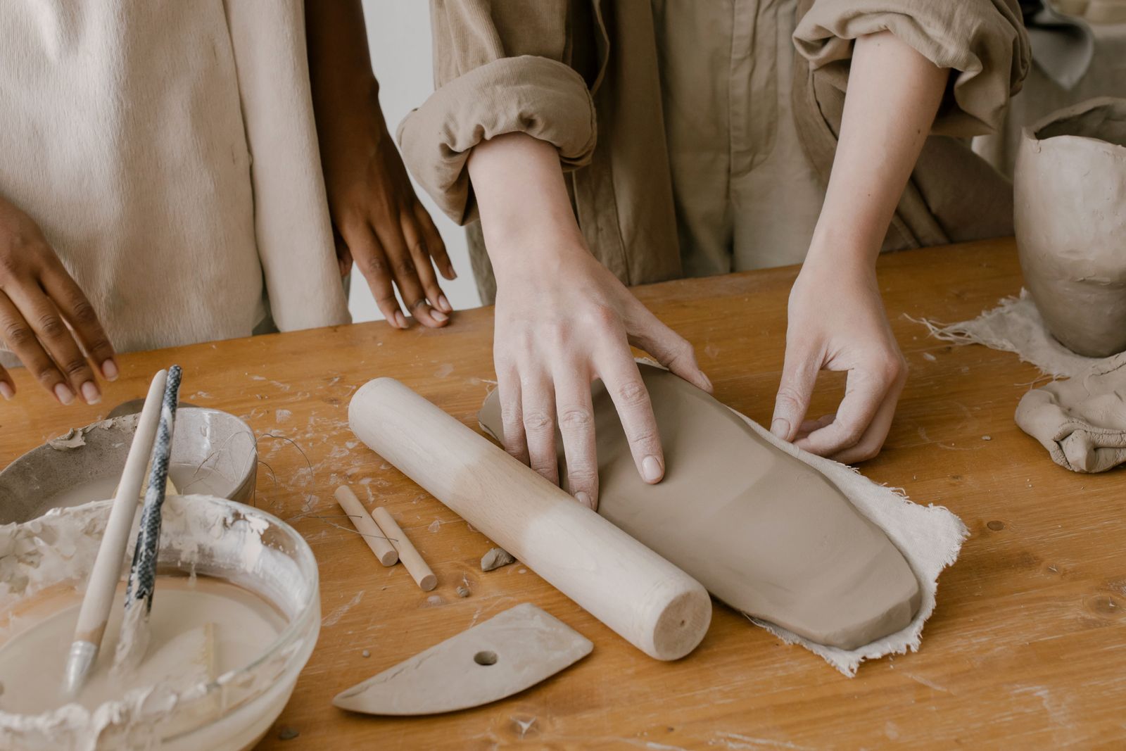 Hands rolling a slab of clay