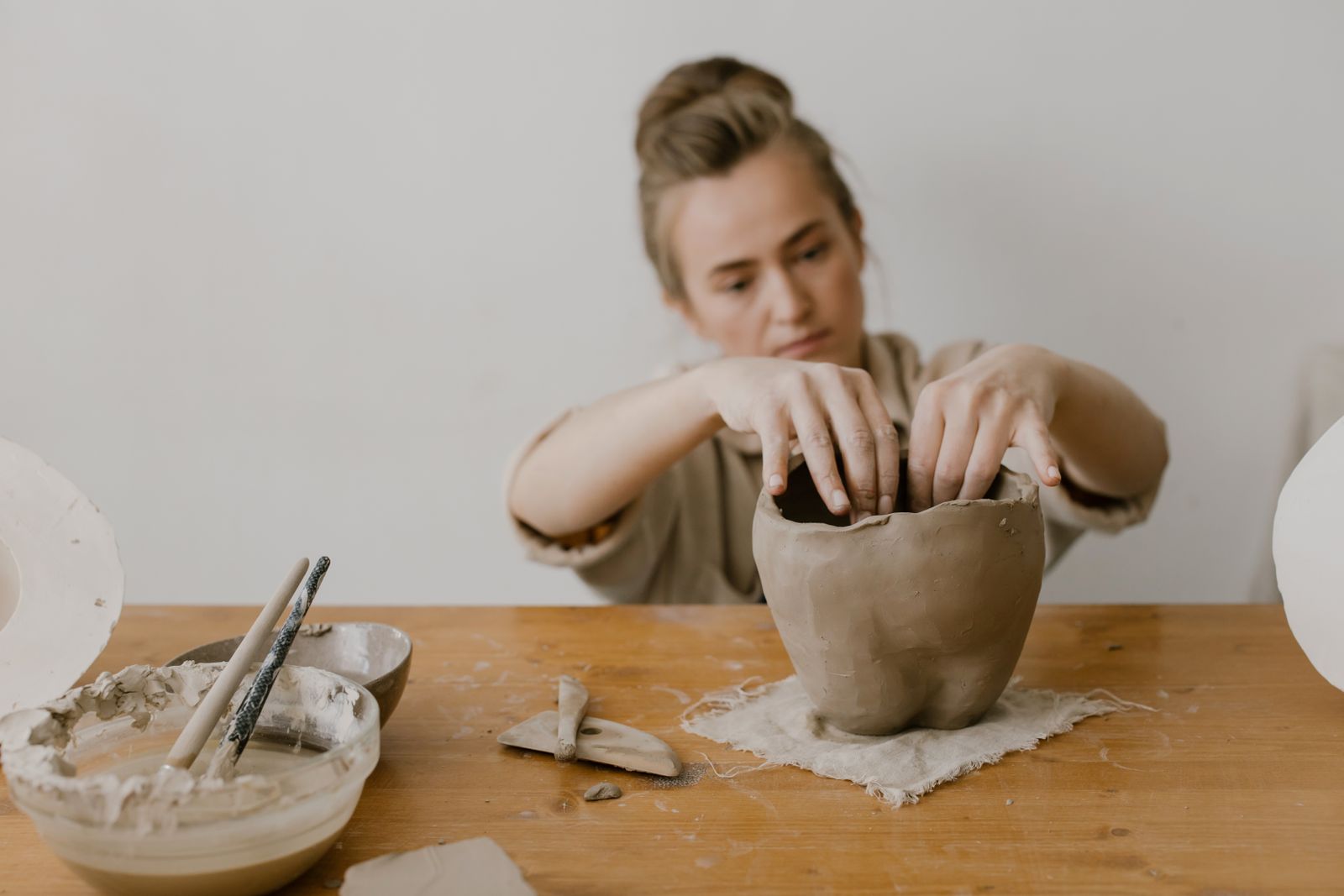 Maker hand-building a clay vessel